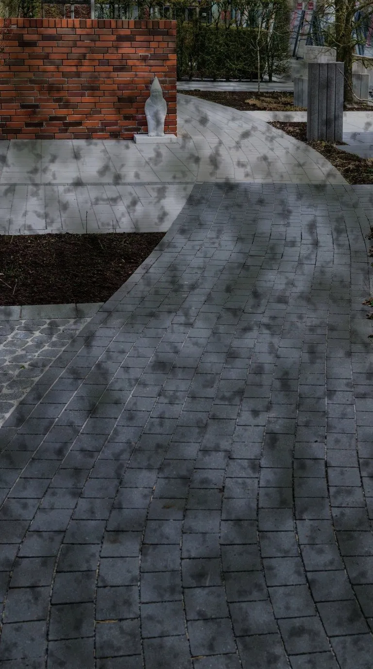 A brick and cobble garden path greened with algae and dulled by weathering